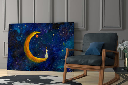 Glass wall art depicting a figure in white dress standing beneath a glowing golden crescent moon against a deep blue starry night sky, displayed in a modern living room setting.