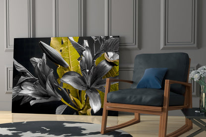 Gold Leaf Lilies on Black Glass Wall Art displayed in modern living room next to wooden chair with blue cushion.