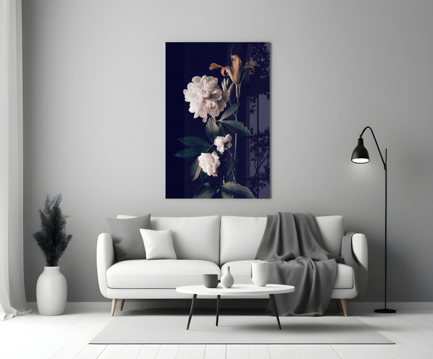 White rose glass wall art displaying pale flowers on dark navy background, displayed above light gray sofa in minimalist living room setting.