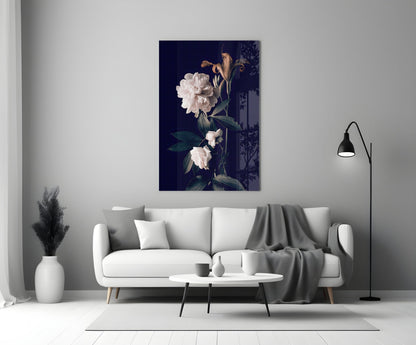 White rose glass wall art displaying pale flowers on dark navy background, displayed above light gray sofa in minimalist living room setting.