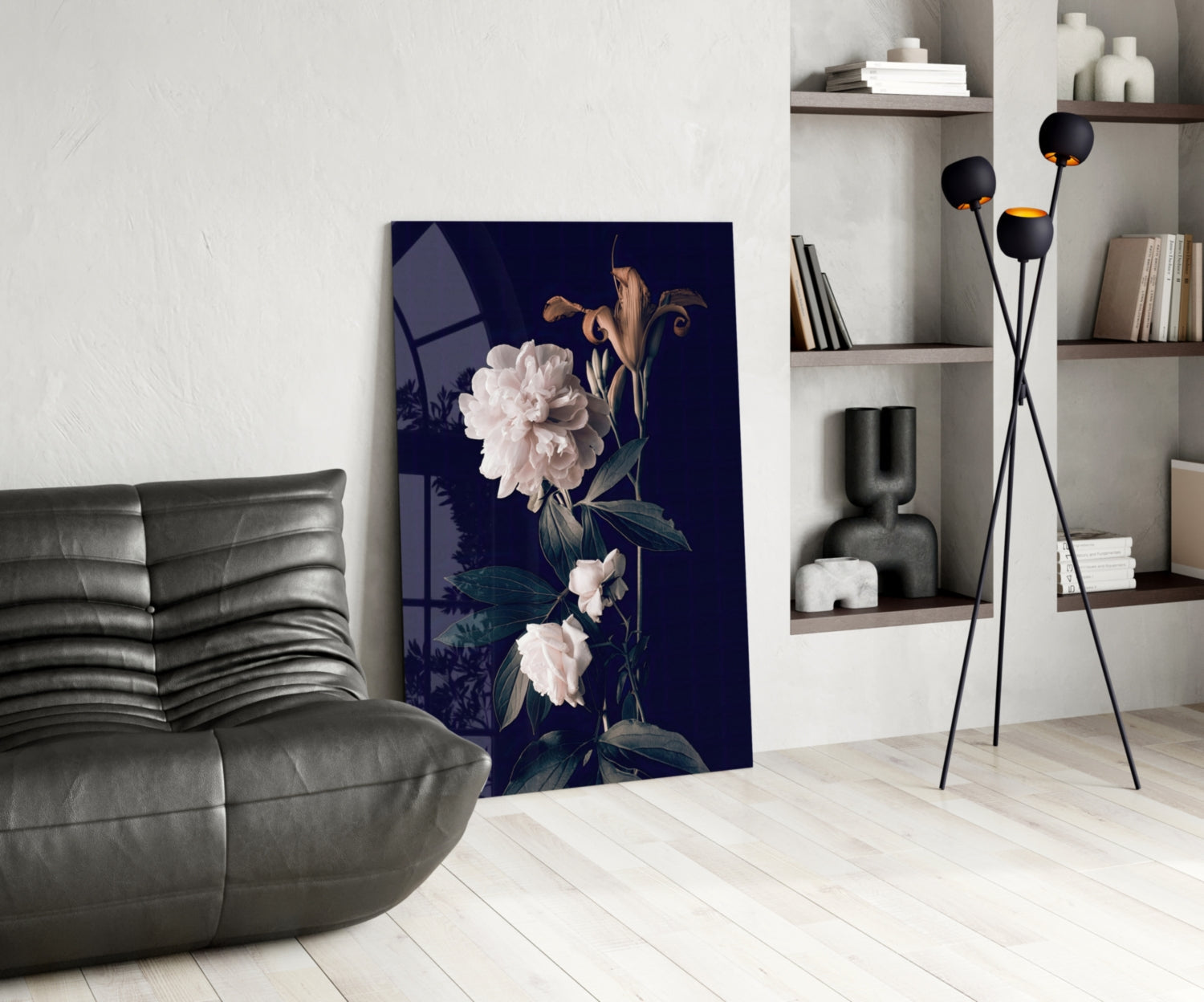 White rose glass wall art with dark navy background displayed in modern living room beside gray leather chair and black floor lamp.