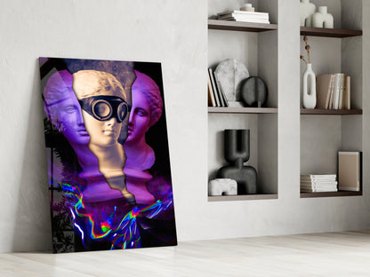 Modern glass wall art featuring three colorful sculptural heads with purple lighting and neon elements leaning against white wall beside shelving.