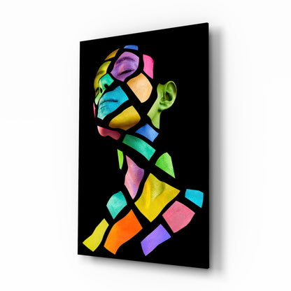 Angled view of glass wall art featuring a colorful mosaic-style profile head with vibrant geometric shapes on black background.