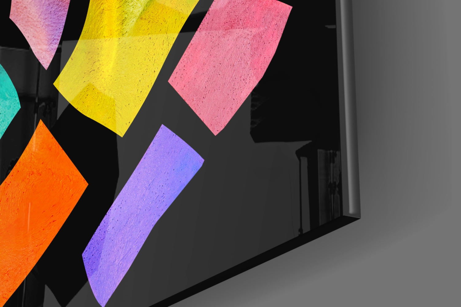 Colorful glass panels in yellow, pink, purple, orange, and turquoise arranged at angles on a black wall surface.