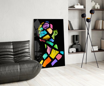 Colorful Spirit Glass Wall Art displayed in modern living room beside gray leather sofa and tall floor lamp with black spherical shades.