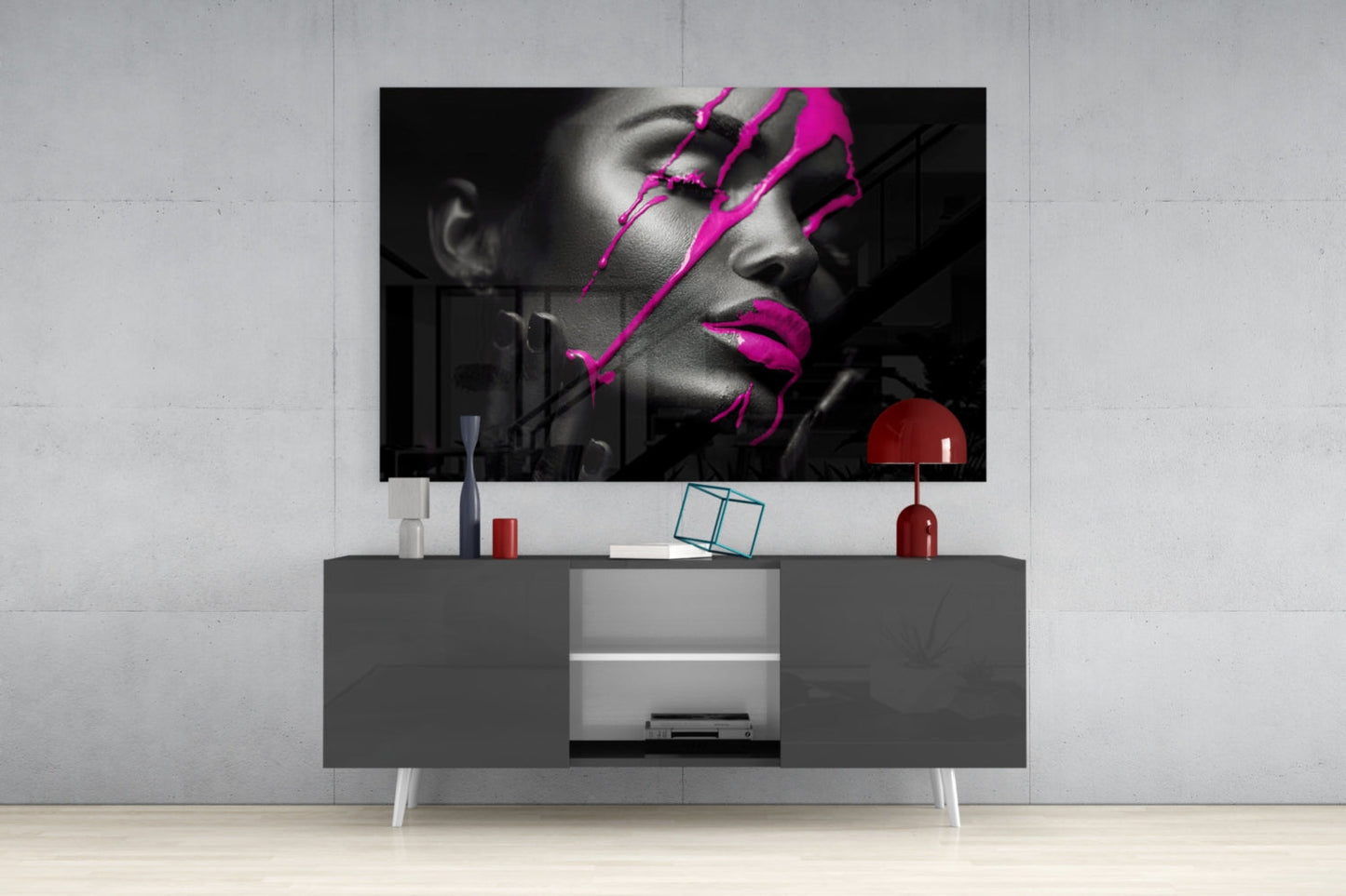 Modern living room setup displaying black and white portrait with magenta artistic overlays mounted above gray media console.