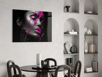 Black and white portrait with bright magenta geometric lines displayed above a round dining table in a minimalist interior.