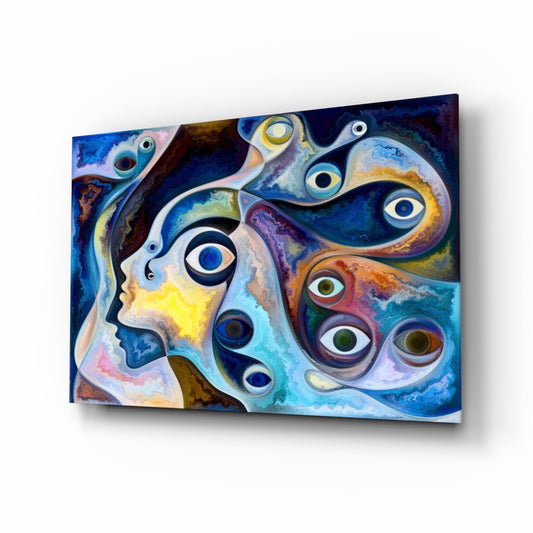 Angled three-quarter view of colorful glass wall art featuring surreal blue and yellow faces with multiple overlapping eyes in jewel tones.