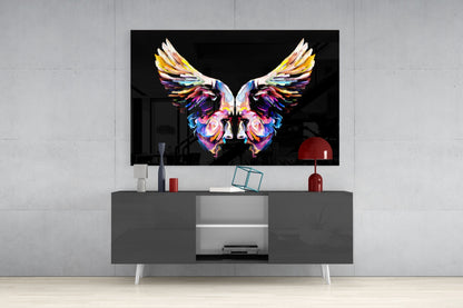 Colorful glass wall art displaying symmetrical butterfly wings with vibrant rainbow hues mounted above a gray media console in a modern living room setting.