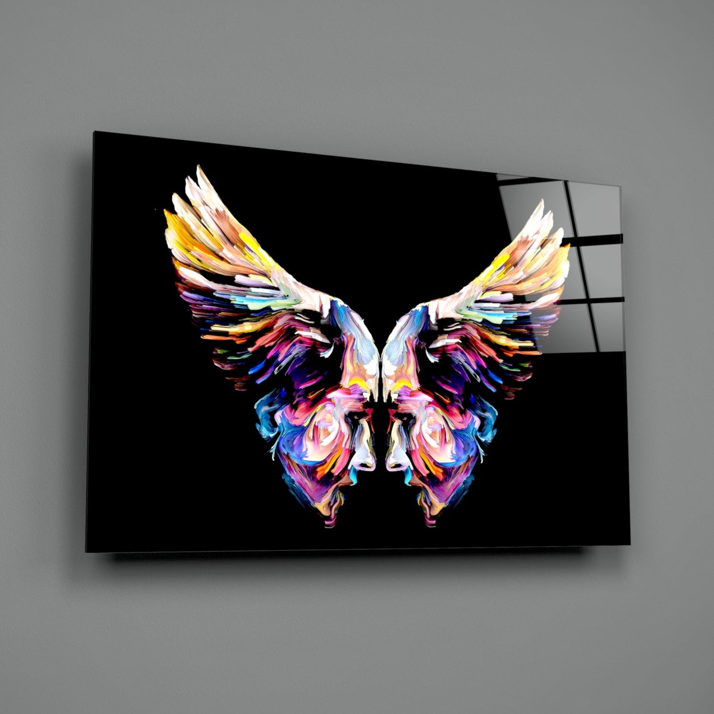 Colorful symmetrical butterfly with vibrant rainbow wings displayed on black glass wall art panel.