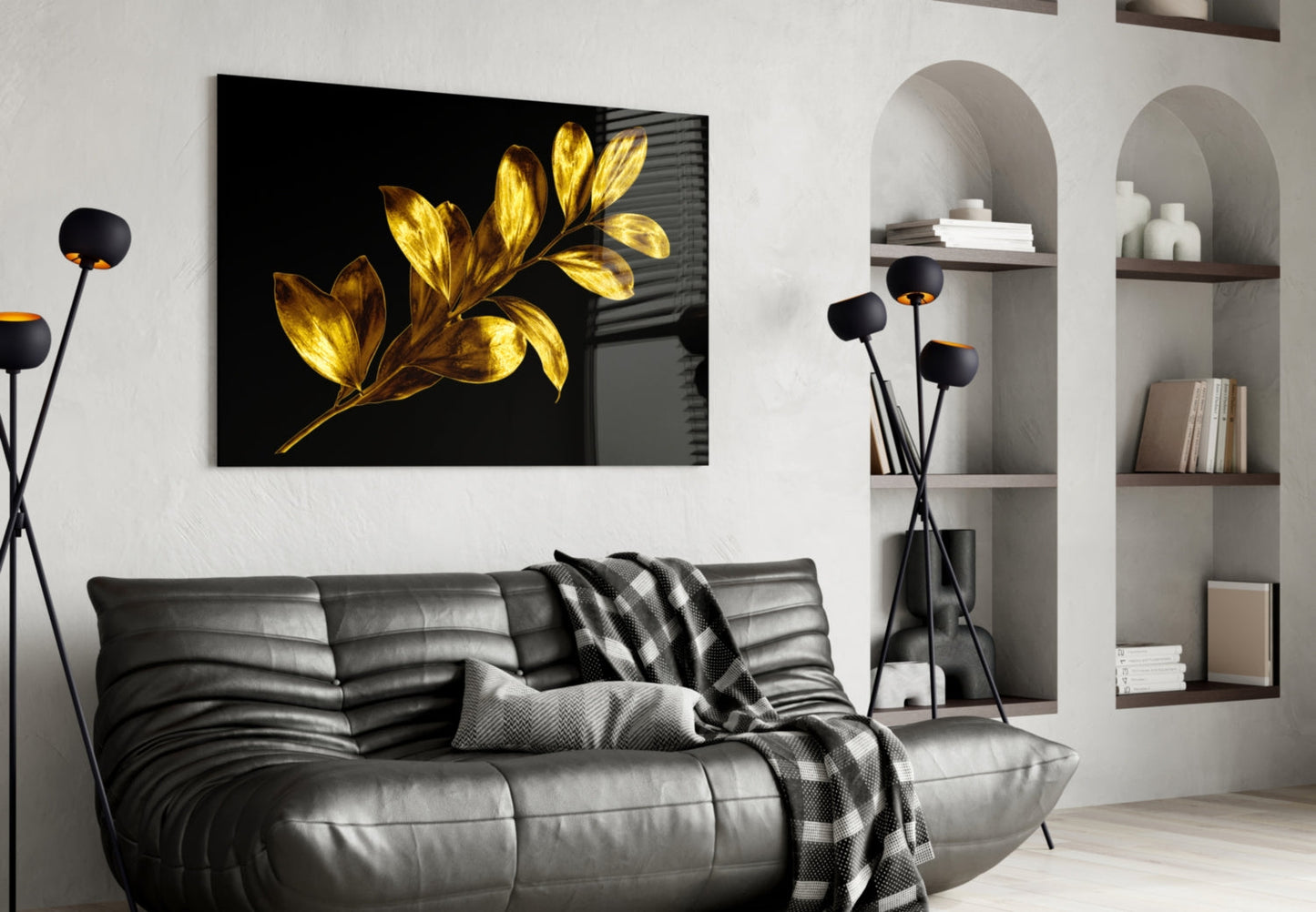 Black glass wall art with golden illuminated leaf branches displayed above a grey leather sofa in modern living room.