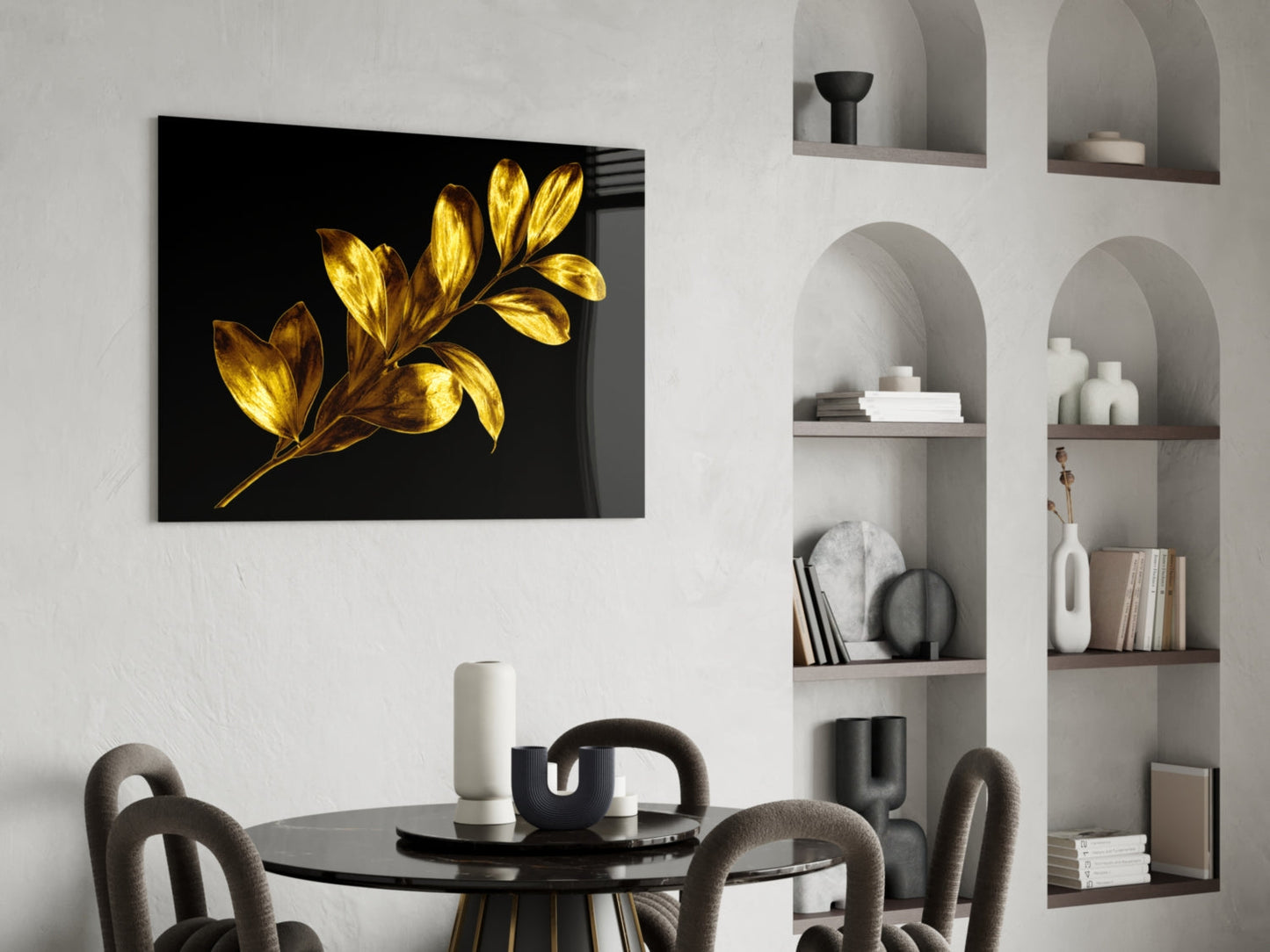 Gold-leafed botanical glass artwork with black background displayed above a round dining table in a modern interior setting.
