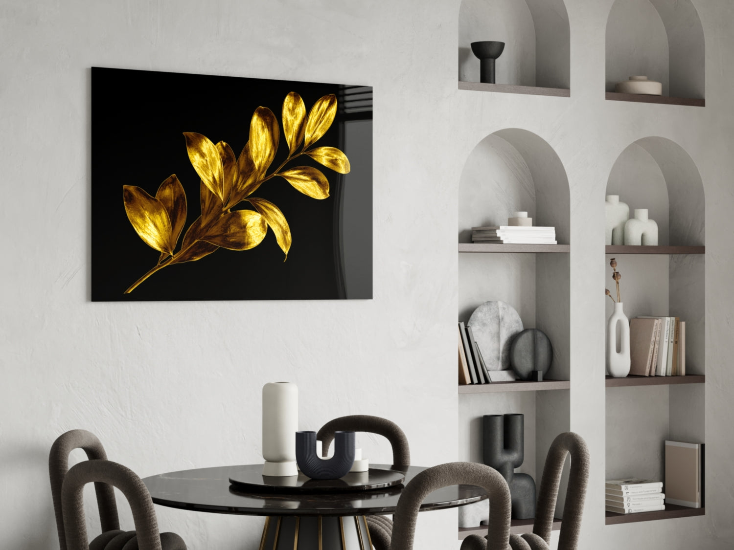 Gold-leafed botanical glass artwork with black background displayed above a round dining table in a modern interior setting.