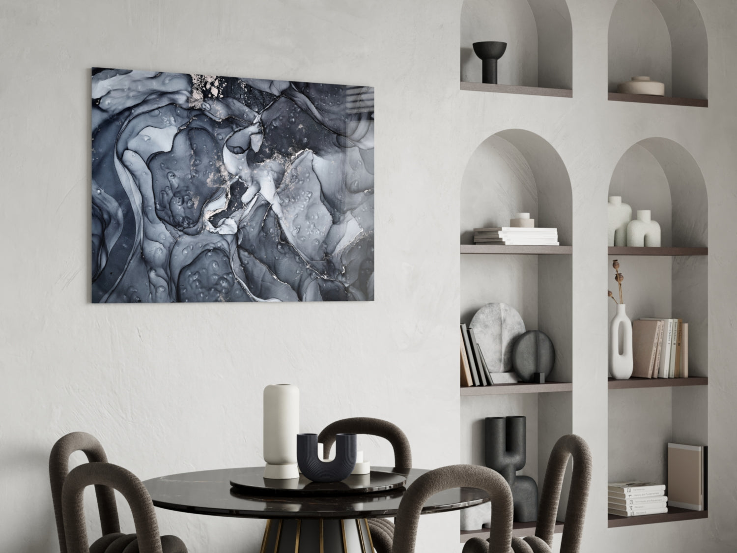 Gray Smoke Glass Wall Art mounted above a black round dining table with upholstered chairs, displaying abstract swirling patterns in shades of gray and white.