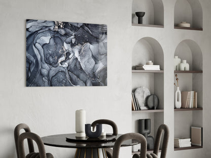 Gray Smoke Glass Wall Art mounted above a black round dining table with upholstered chairs, displaying abstract swirling patterns in shades of gray and white.