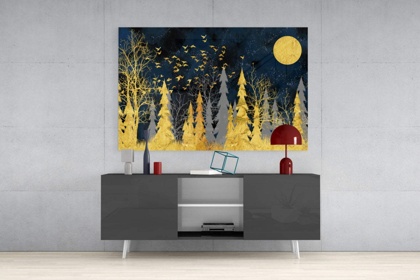 Modern living room with dark gray media console displaying framed glass wall art featuring gold forest silhouettes, full moon, and flying birds against dark blue night sky.