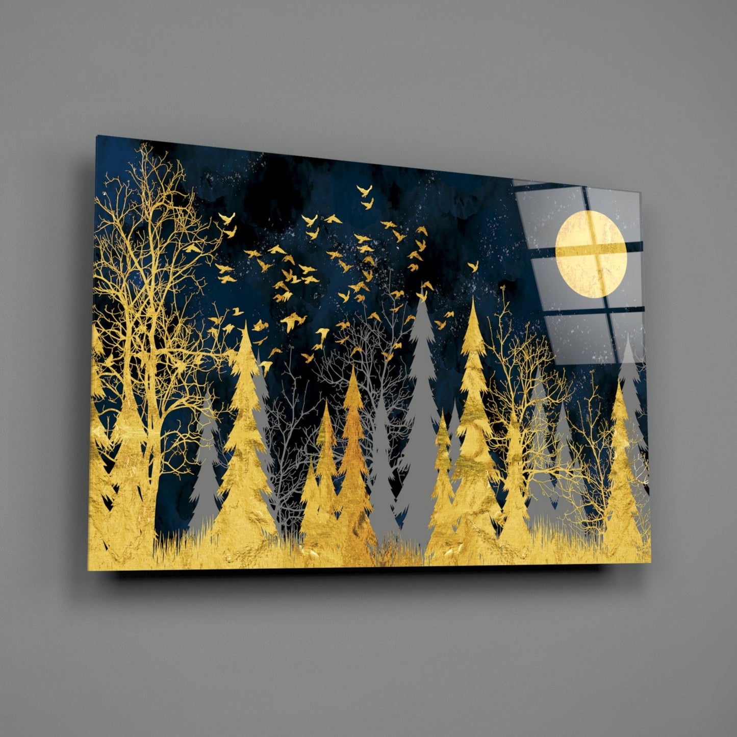 Glass wall art panel featuring a nighttime forest scene with golden trees and birds against a dark blue sky with a full moon, displayed at an angle against a gray background.