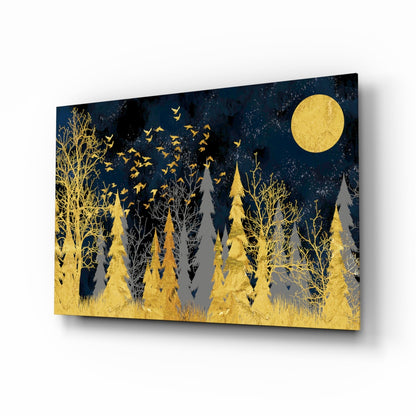A glass wall art panel displaying a gold forest landscape with trees, flying birds, a full moon, and dark blue night sky background, shown at an angled perspective.