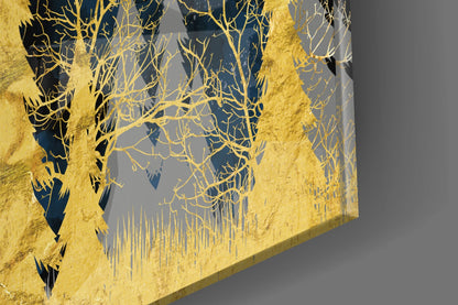 Close-up angled view of gold-foiled bare tree branches and grass silhouettes on dark blue and gray glass panel.