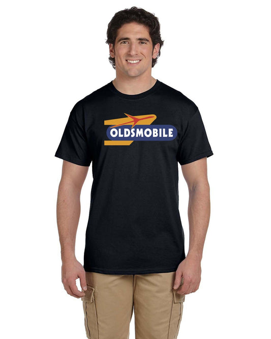 Front view of a smiling man wearing a black tee with a gold, red and navy Oldsmobile logo.