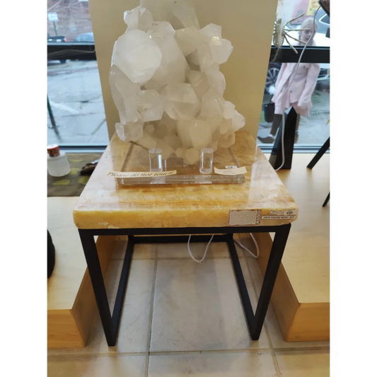 Onyx nesting table with translucent white quartz crystal cluster on yellow marble