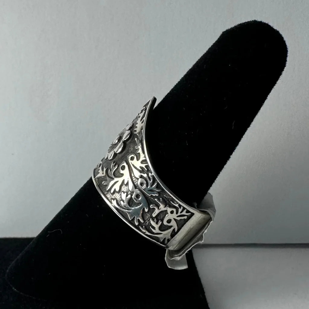 Silver cuff bracelet with ornate floral vine patterns