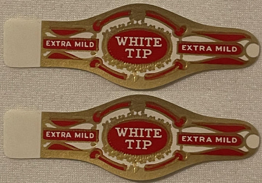 Two antique White Tip Extra Mild cigar bands, one above the other: WHITE TIP in white on a red oval framed in raised gold, EXTRA MILD in red panels on each side, cream paper tab.