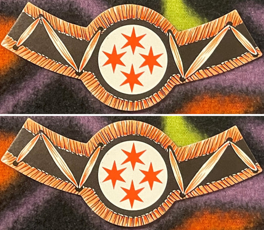 Two four-star wine bottle neck labels, one above the other on a colorful fleece: four red six-pointed stars in a white circle, black wings with copper-orange feathered edges.