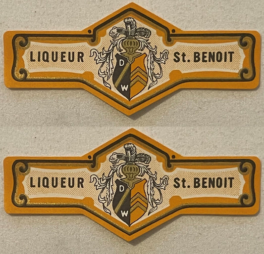 Two antique orange St. Benoit liqueur neck labels, one above the other: LIQUEUR and St. BENOIT either side of a plumed helm over a D W shield with chevrons, black and gold rules.
