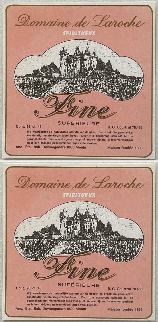 Two Domaine de Laroche Fine Supérieure labels, one above the other: pink with gold script and a black engraving of a turreted castle over vineyards