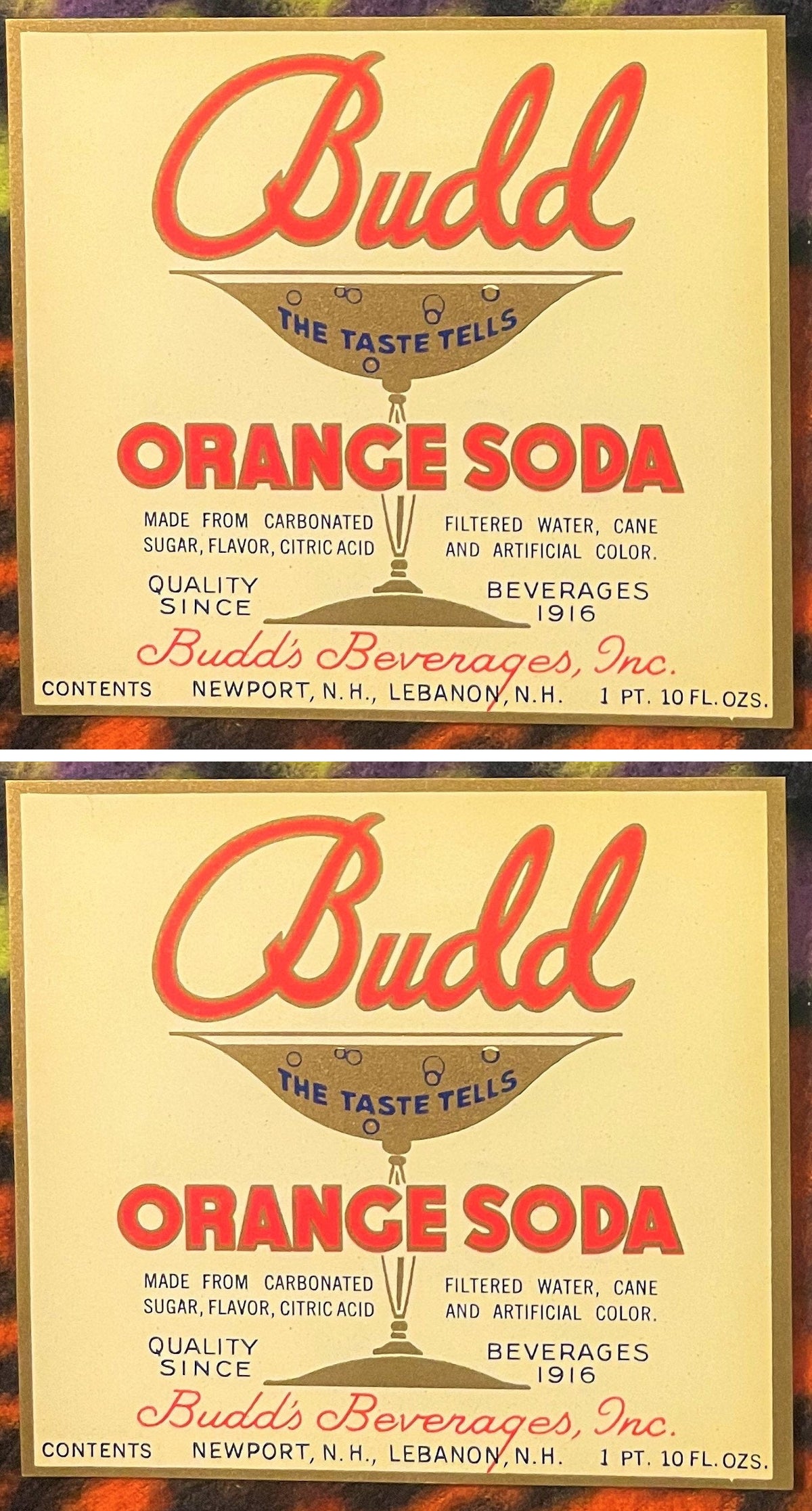 Two Budd Orange Soda labels, one above the other: red Budd script over a gold soda glass reading THE TASTE TELLS, red ORANGE SODA, Budd's Beverages, Inc., Newport, N.H., Lebanon, N.H.