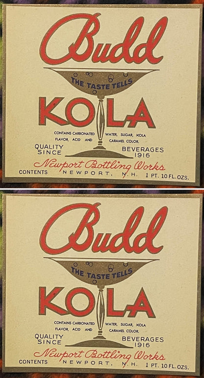 Two Budd Kola labels, one above the other: red Budd script over a gold cocktail glass reading THE TASTE TELLS, KOLA in red split by the glass stem, Newport Bottling Works, Newport, N.H.