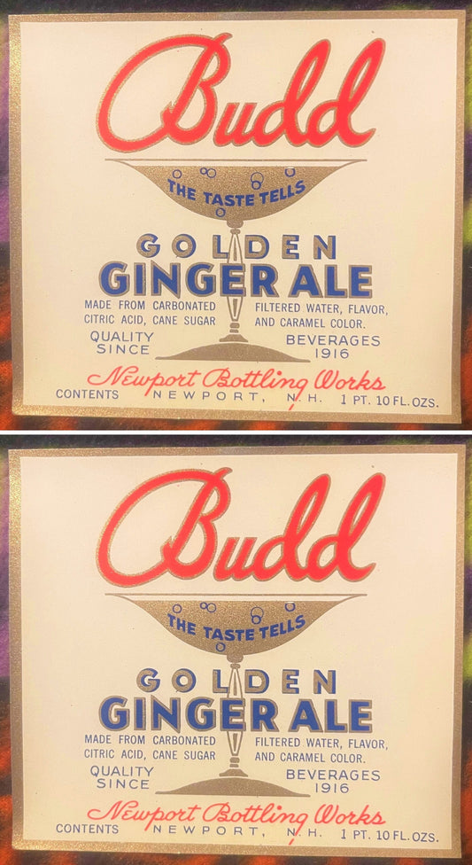 Two Budd Golden Ginger Ale labels, one above the other: red Budd script over a gold soda glass reading THE TASTE TELLS, GOLDEN GINGER ALE in blue, Newport Bottling Works, Newport, N.H.