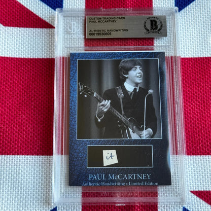 A black custom trading card featuring paul mccartney playing guitar with authentic handwriting, limited edition rock n roll collectible