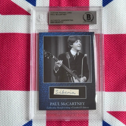 A black and blue custom paul mccartney trading card with authentic handwriting encased in a clear protective slab highlighting rock n roll and music history
