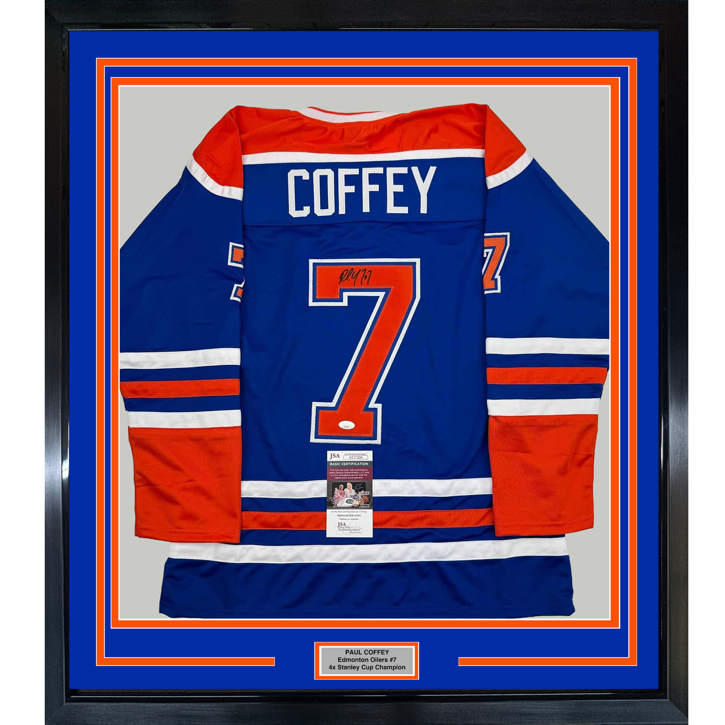 Framed Edmonton Oilers blue hockey jersey number 7 signed by Paul Coffey, displayed front-facing with red and white stripes and JSA authentication certificate visible.