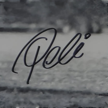 Pele autographed Brazil soccer photo with black cursive poli signature on textured surface