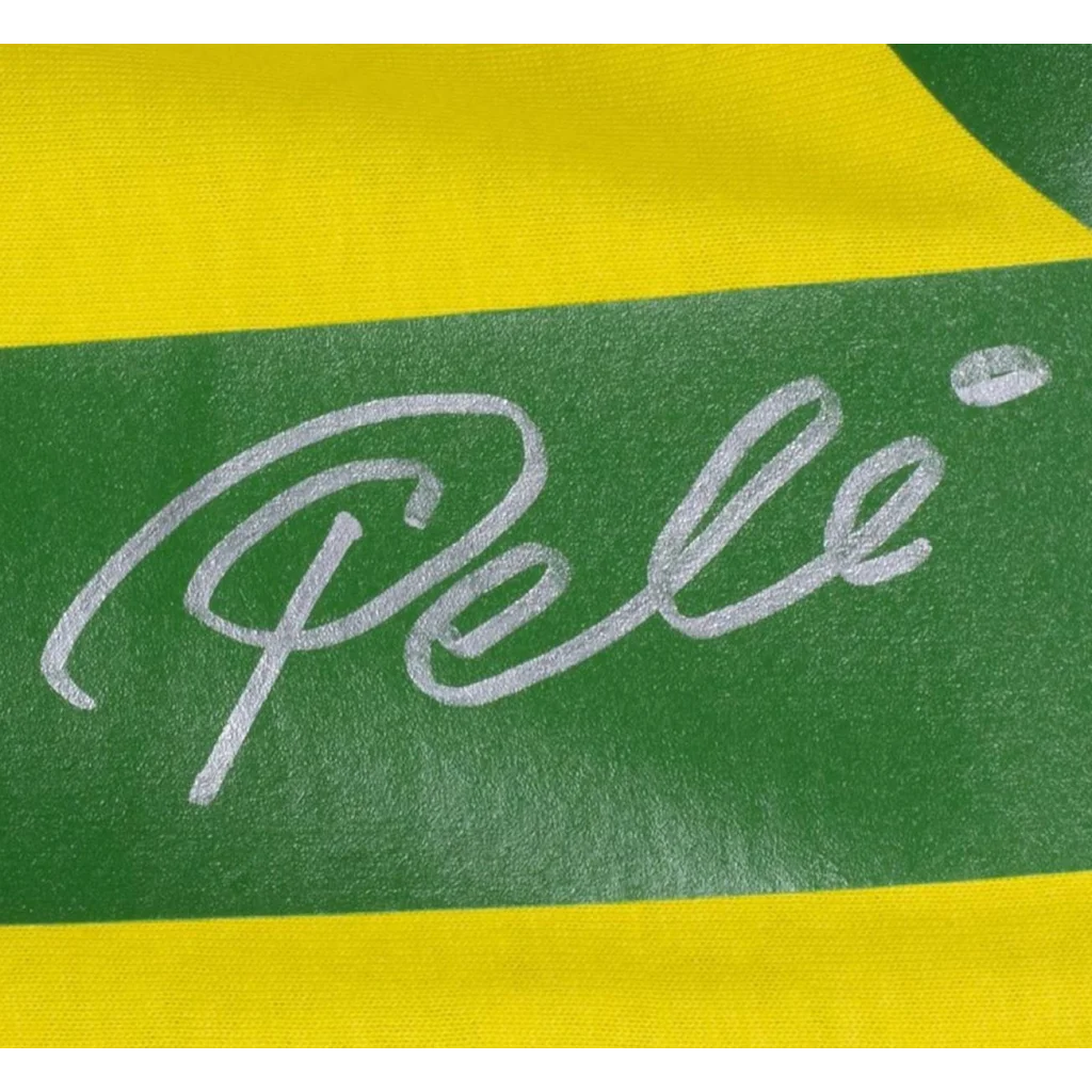 Pele autographed Brazil replica soccer jersey with silver cursive Pele signature on green and yellow striped fabric