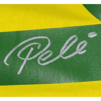 Pele autographed Brazil replica soccer jersey with silver cursive Pele signature on green and yellow striped fabric