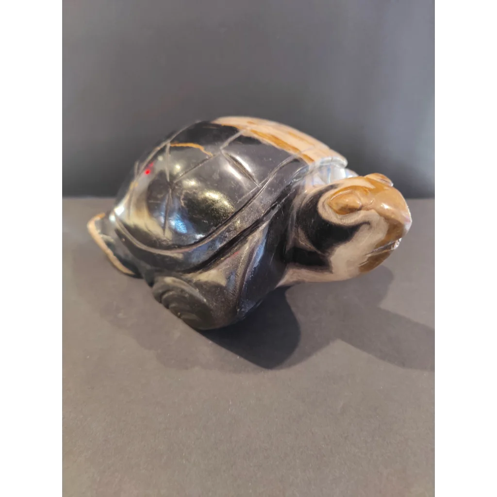 Polished petrified wood turtle sculpture with glossy black shell and tan markings