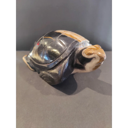 Polished petrified wood turtle sculpture with glossy black shell and tan markings