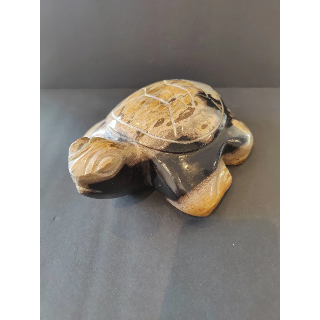 Polished petrified wood turtle sculpture with natural black and golden shell