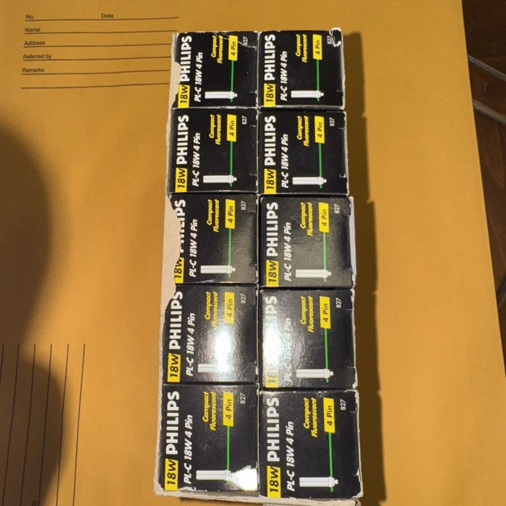 Sixteen Philips 18W PL-C 830 lamp bulbs in black boxes, 10-pack display