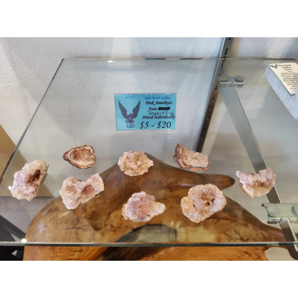 Pink amethyst geodes on wooden stand in glass case (MD)