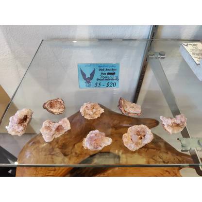 Pink amethyst geodes on wooden stand in glass case (MD)