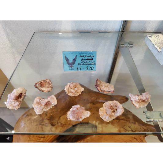 Pink amethyst geodes on wooden stand in glass case (MD)
