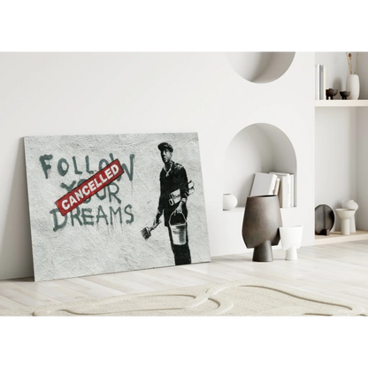 Banksy Dreams Cancelled wall art: gray canvas stencil of worker with bucket and broom, dreams text crossed out