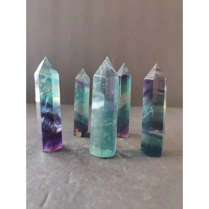 A set of five polished multi-color fluorite tower points in translucent purple teal and blue gradient measuring 3 inches