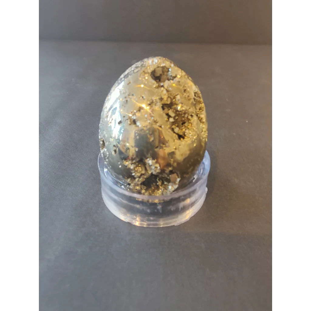 A polished pyrite egg with metallic gold sheen on dark matrix from polished pyrite spheres collection