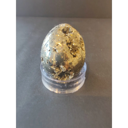 A polished pyrite egg with metallic gold sheen on dark matrix from polished pyrite spheres collection